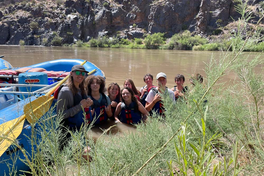 Group of Adventures students swimming in the river during a rafting trip