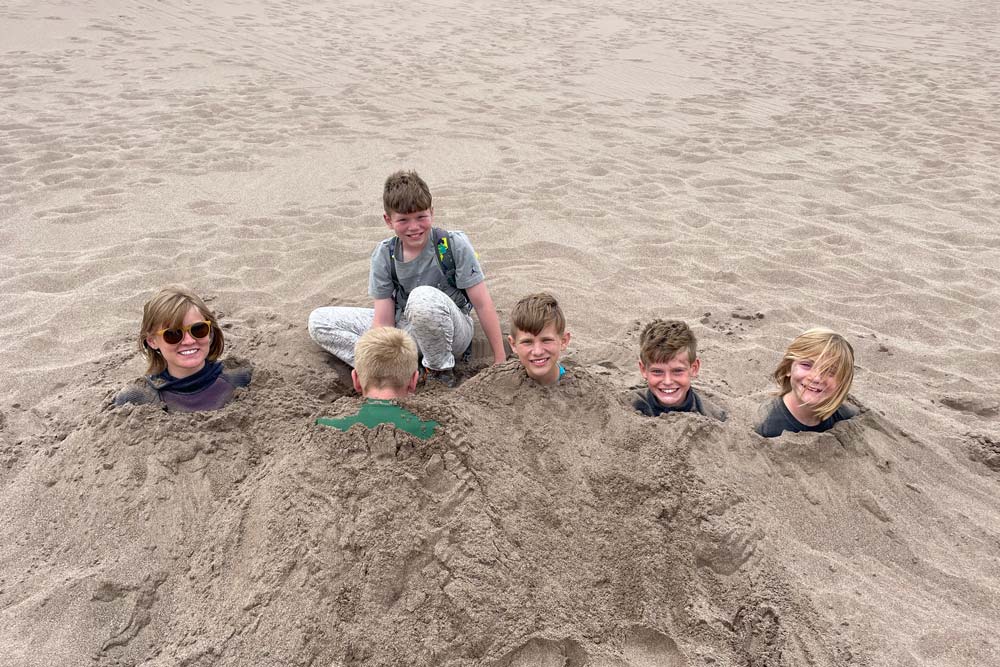 Adventure students buried in the sand in the Sand Dunes National Park