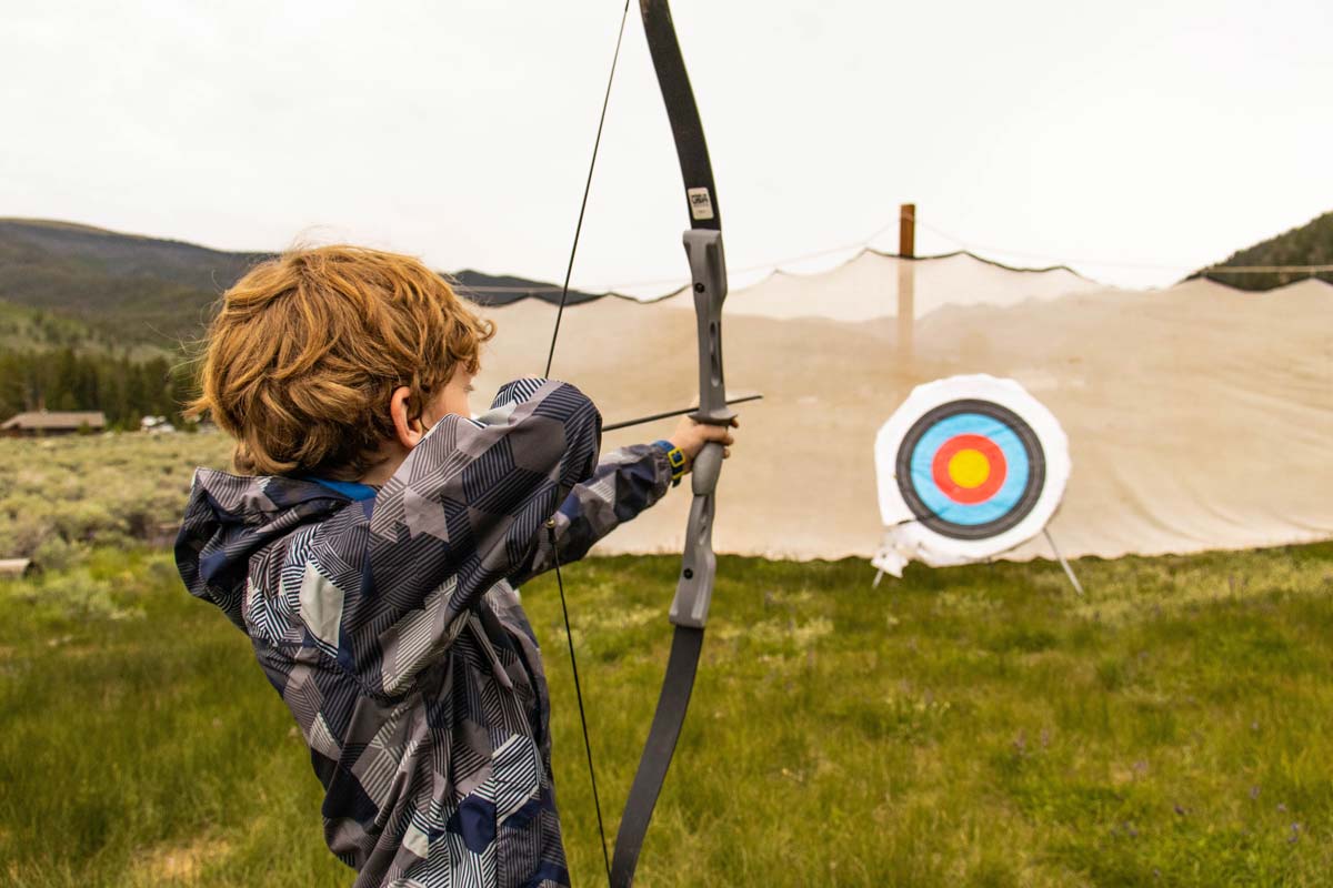 Camper aiming at the archery target during Camper Choice