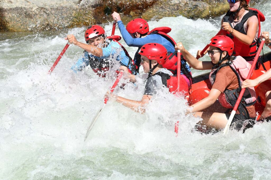 A group of campers splashed in the whitewater rafting rapids