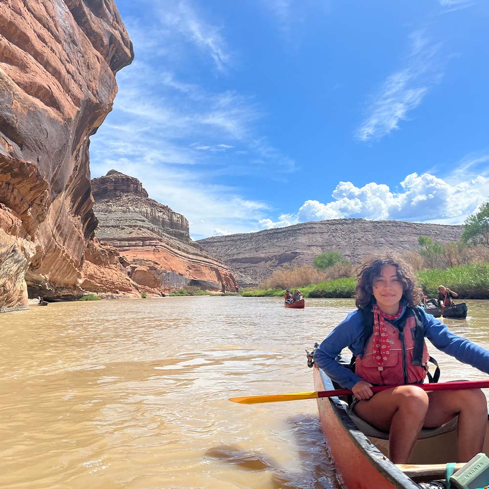 A Adventures girl canoes downstream in the desert