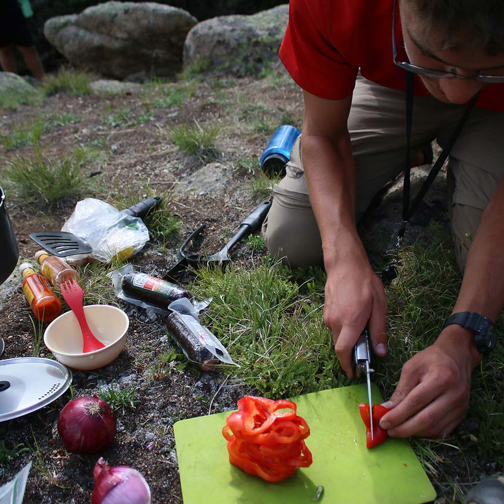 A student cooks dinner back at camp.