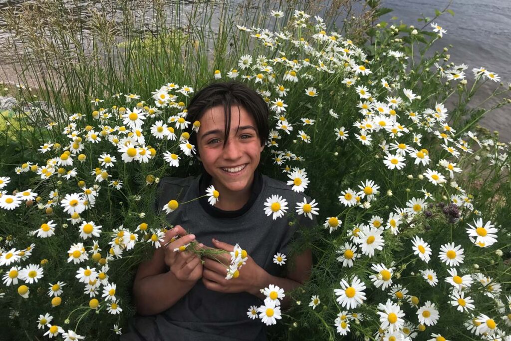 An Adventures student laying in the wildflowers