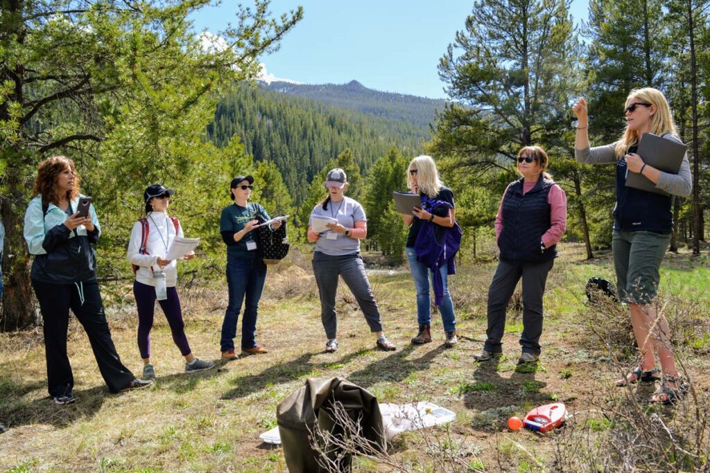 Teachers in Beyond the Classroom stand in a group outside on the trail.