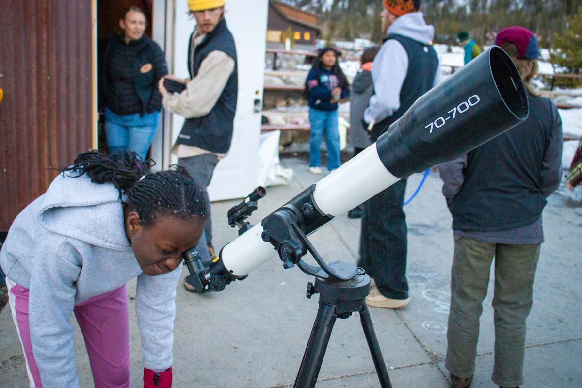 A local Summit County student looks through a telescope at the stars in our Silverthorne Overnight Outdoor Education program.