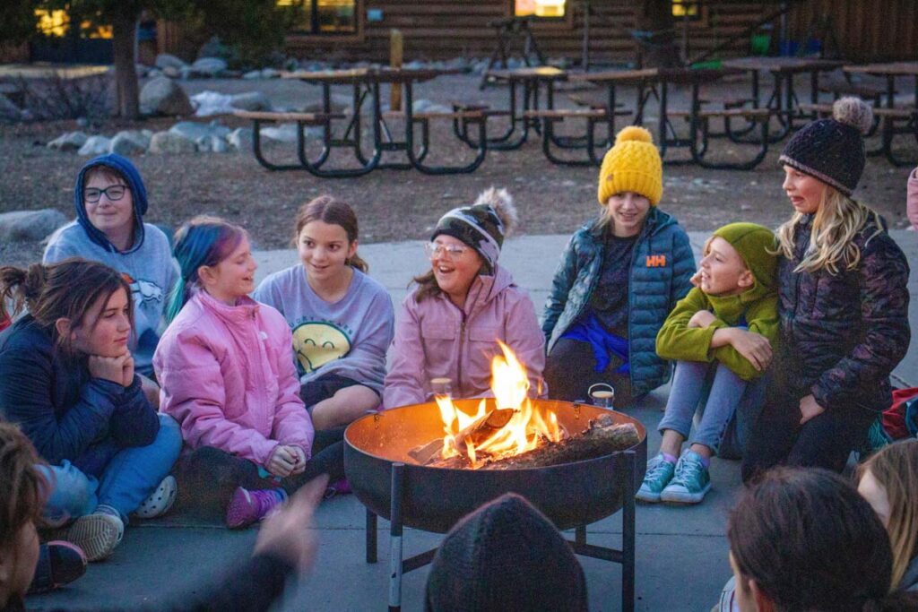 A group of Girls in STEM students enjoying a campfire