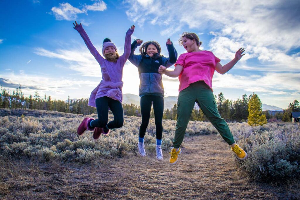 Girls in STEM students jumping at sunset