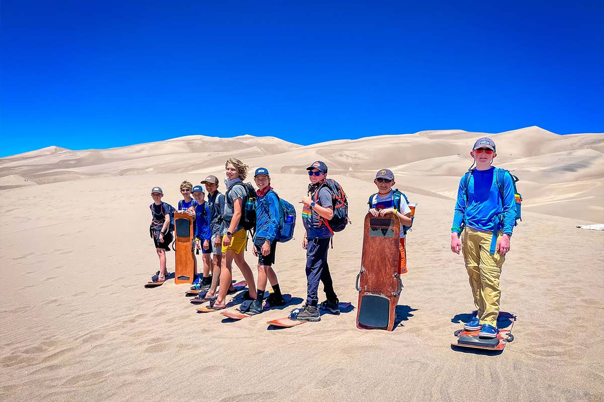 The Adventure group holds their sandboards in the Great Sand Dunes National Park.