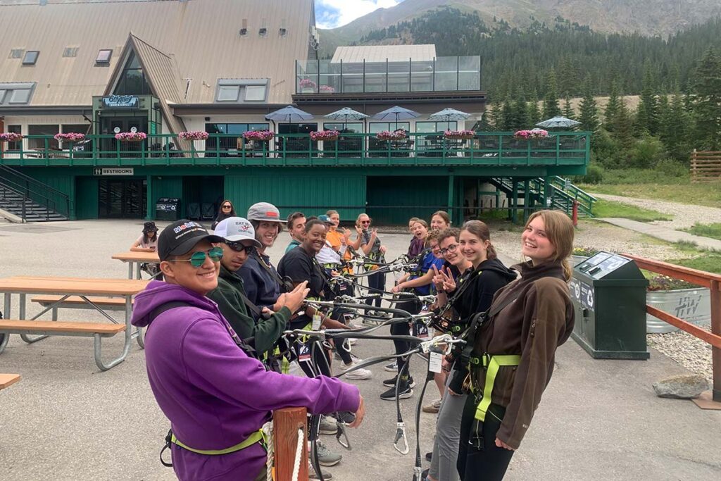 A group of CAPs putting on harnesses for the ropes course