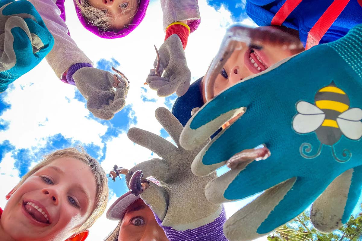 Day Campers show their garden gloves during a field trip day.