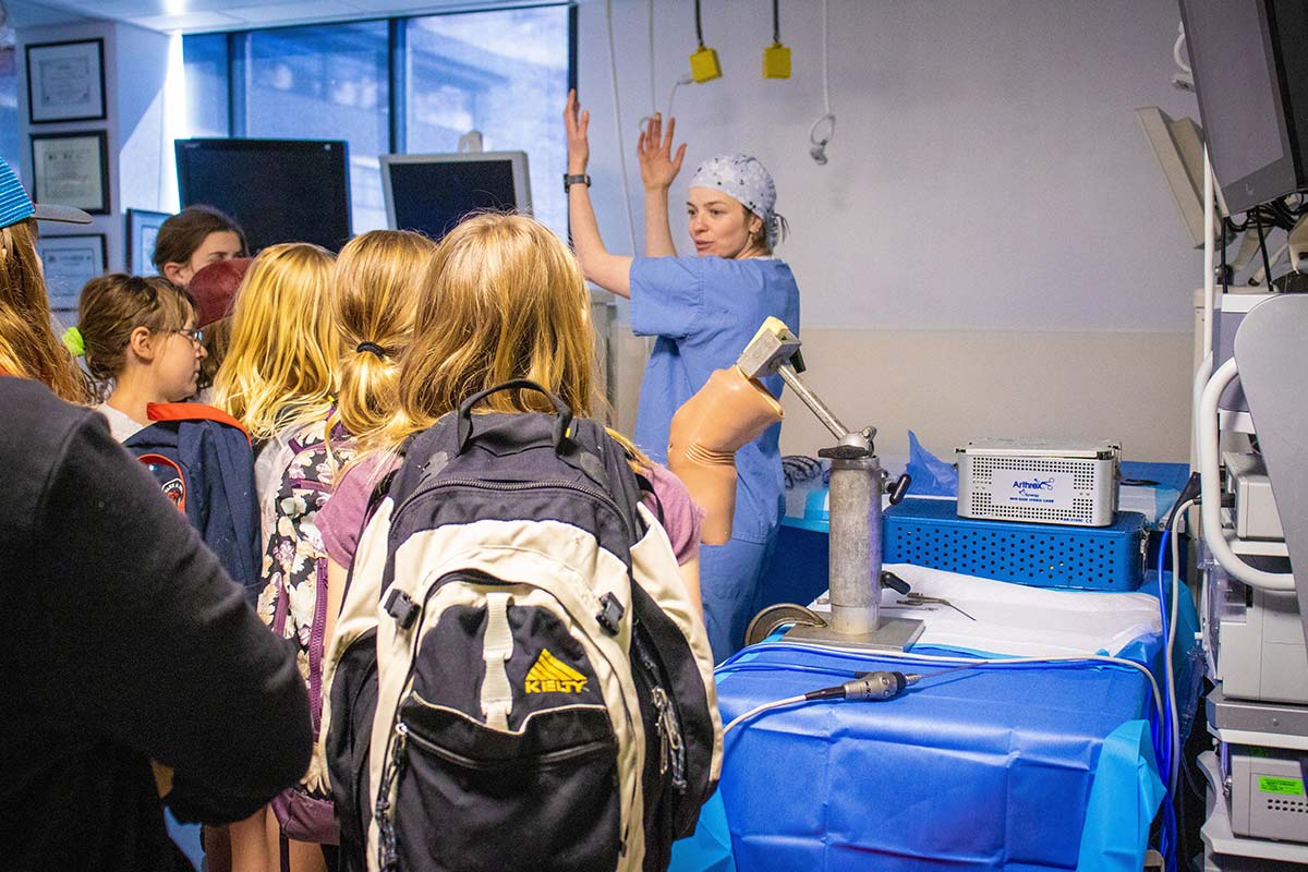 The group listens to a lab tech mentor