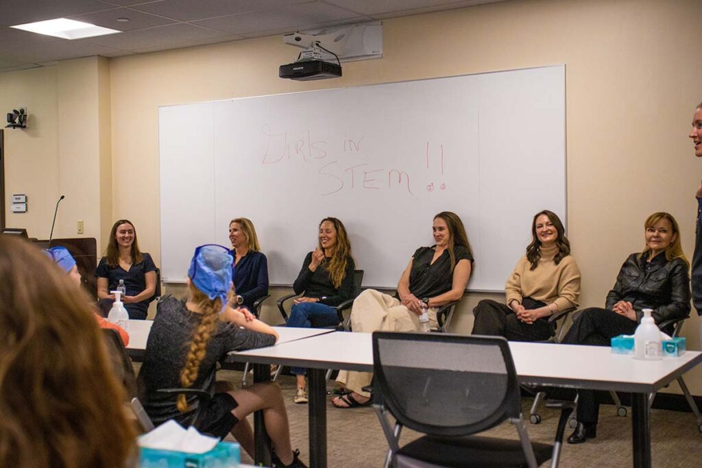 Female mentors speak with students in Girls in STEM Biomedical