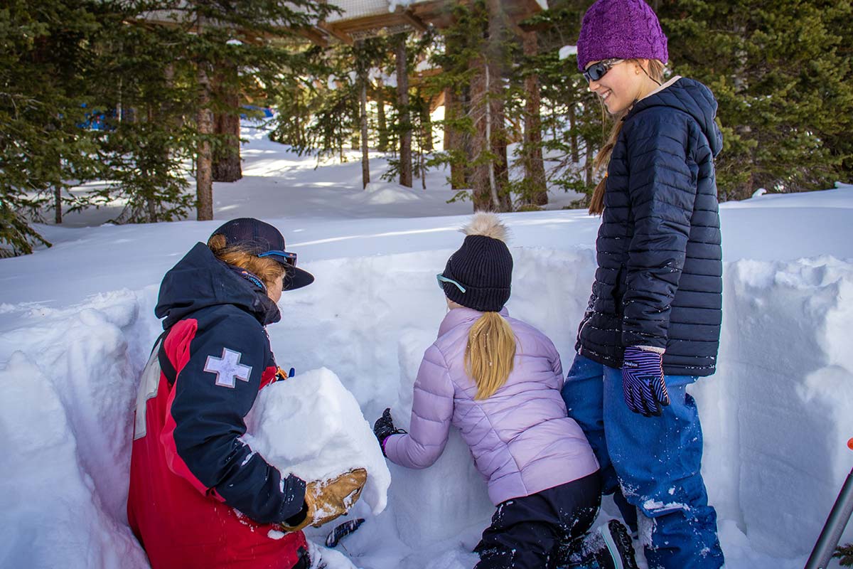 Girls in STEM Snow and Avalanche students studying a snow pit with a ski patroller