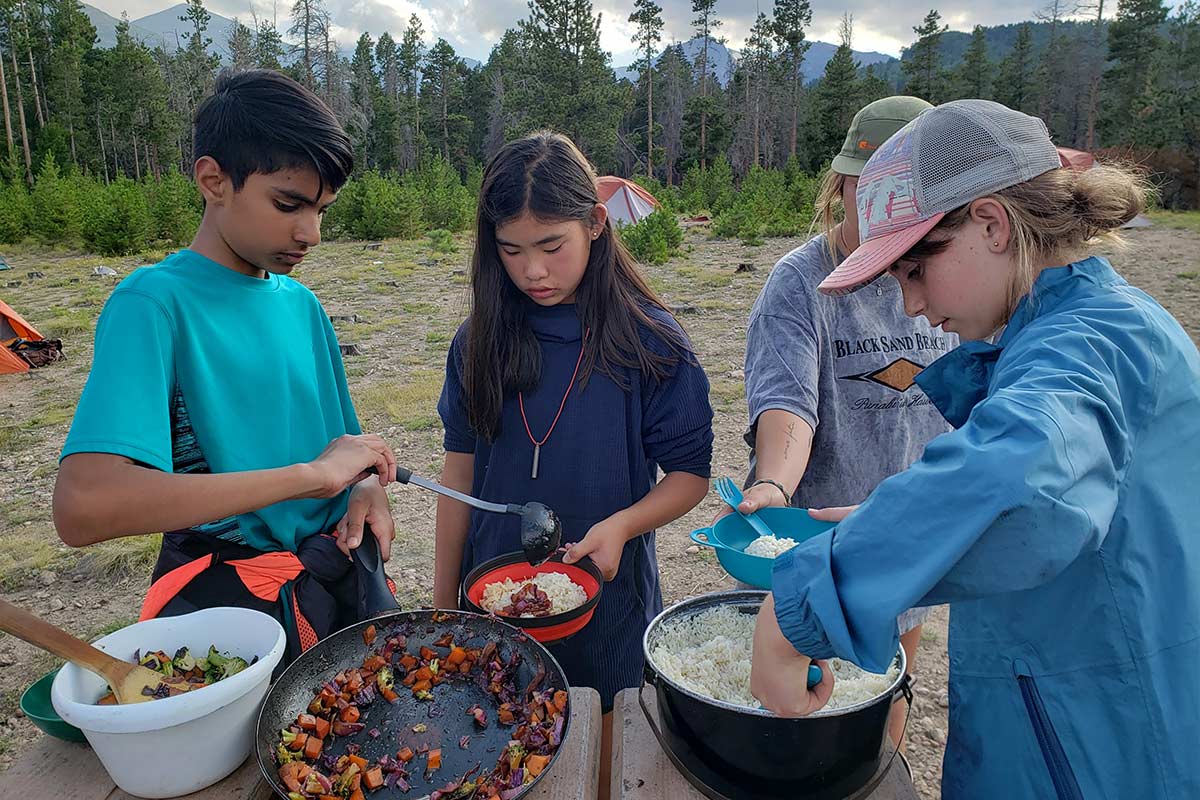 The Outdoor Education students prepare a meal at the campsite.