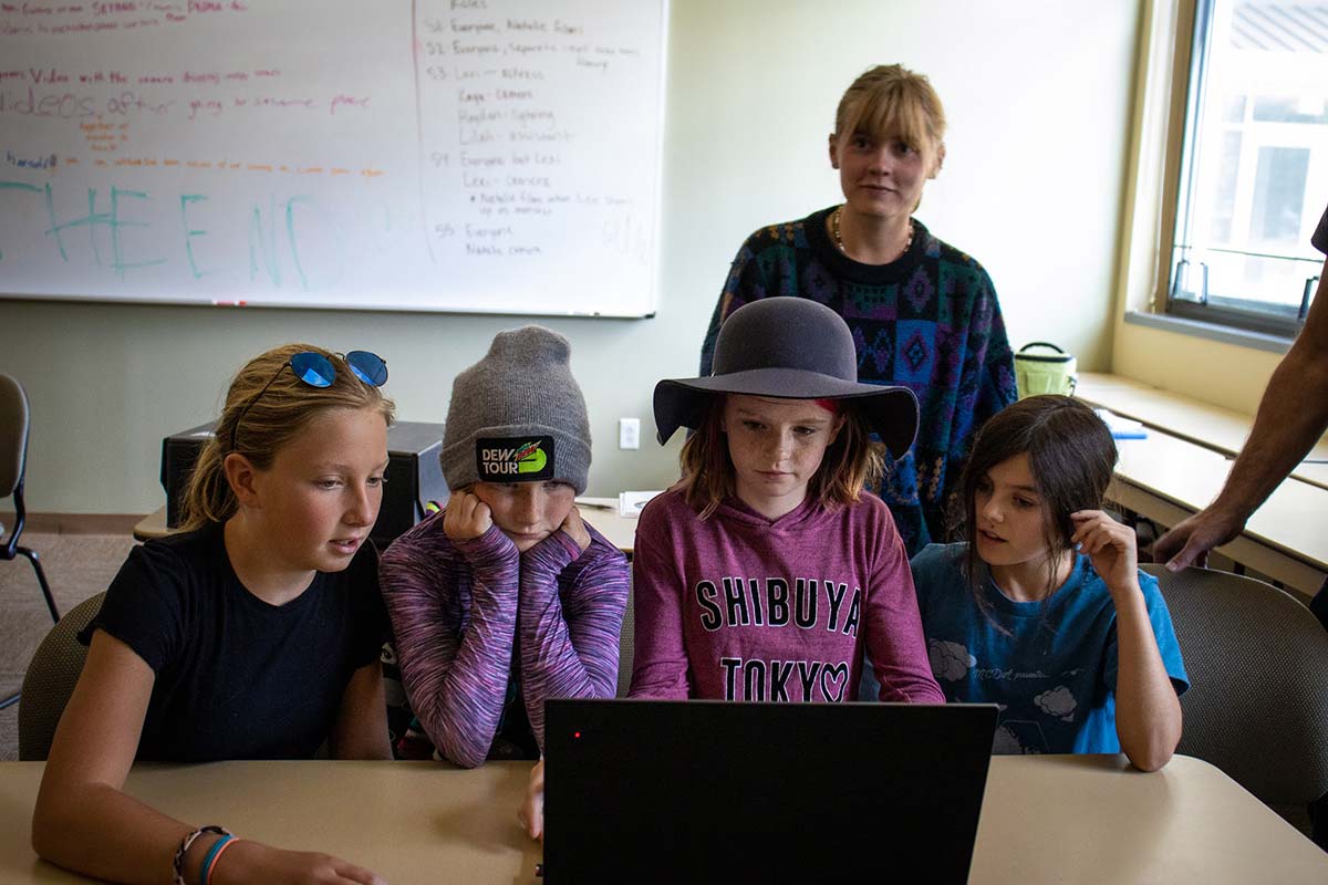 Female students edit video on a laptop during Film Fest