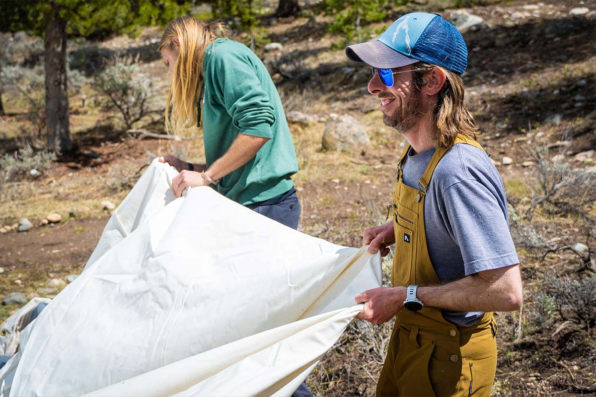 Staff and volunteers spread out a tent tarp on Volunteer Day